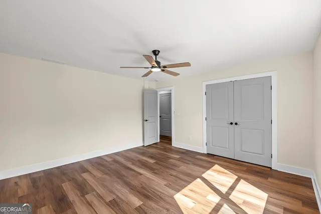 a view of a livingroom with a ceiling fan and wooden floor
