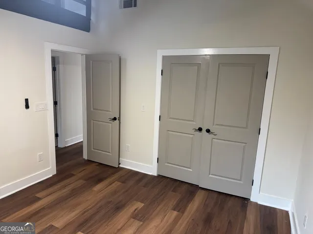 a view of an empty room with wooden floor