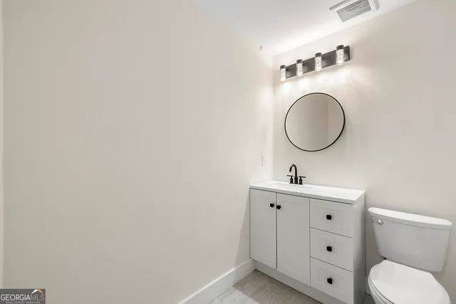 a bathroom with a toilet a sink and mirror