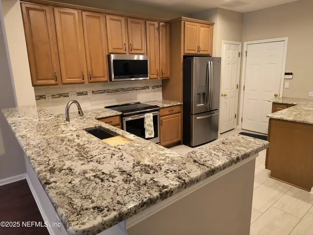 a kitchen with stainless steel appliances granite countertop a sink stove and microwave