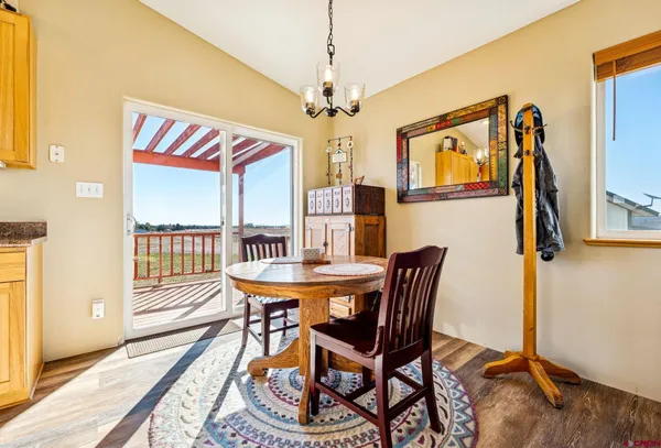 a view of a dining room with furniture a chandelier and wooden floor