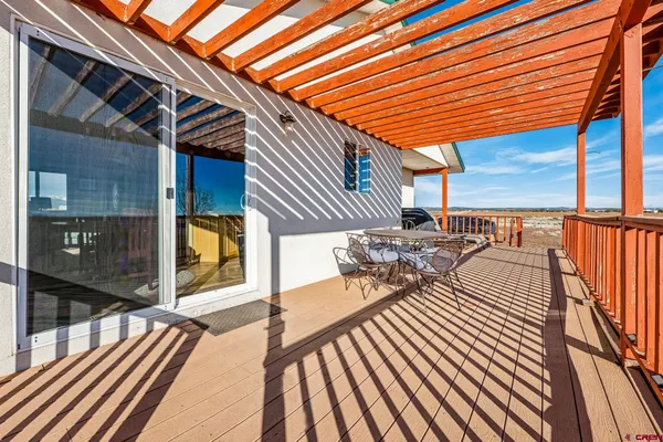 a view of a patio with table and chairs and wooden floor