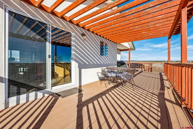 a view of a patio with table and chairs and wooden floor