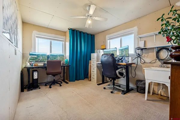 a view of a workspace with furniture and a window