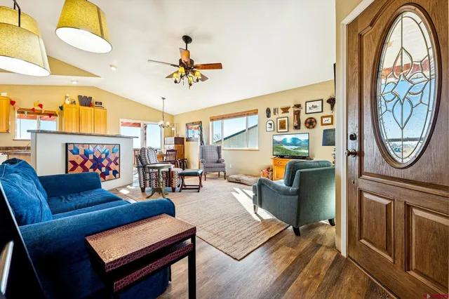 a living room with furniture a fireplace and a chandelier