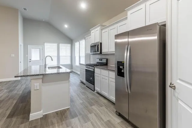 a kitchen with stainless steel appliances granite countertop a sink stove and microwave