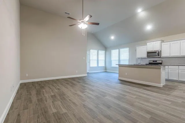 a view of kitchen with granite countertop cabinets and wooden floor