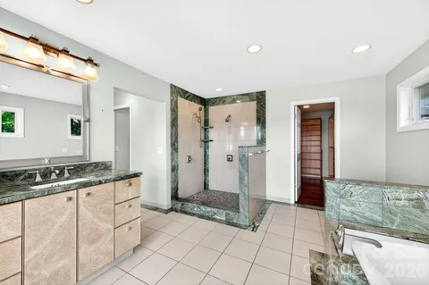 a spacious bathroom with a granite countertop sink and a mirror