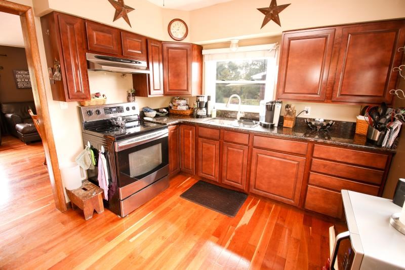 5123 River Road Cherry Valley, IL 61016 - Photo 3 of 15 a kitchen with stainless steel appliances granite countertop sink stove top oven and cabinets