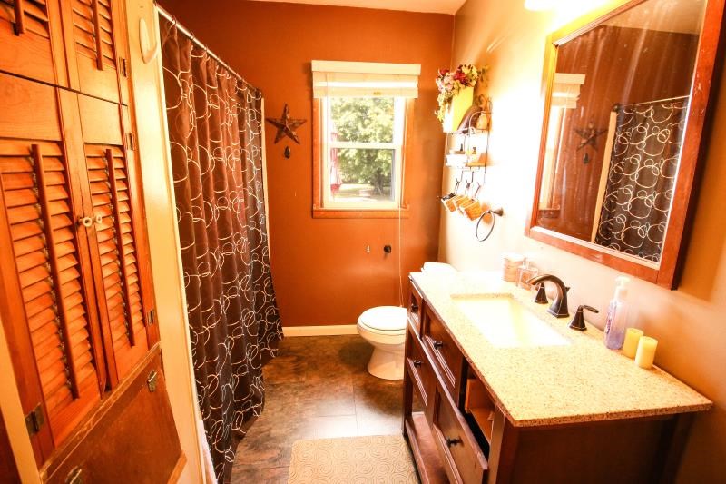 5123 River Road Cherry Valley, IL 61016 - Photo 6 of 15 a bathroom with a sink a toilet and shower curtain