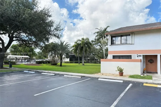 a front view of a house with a yard and trees