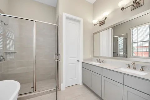 a bathroom with a tub sink shower and mirror