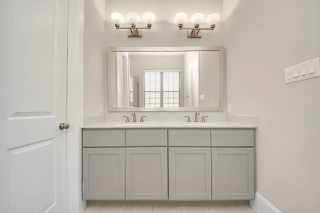 a bathroom with a double vanity sink and a mirror