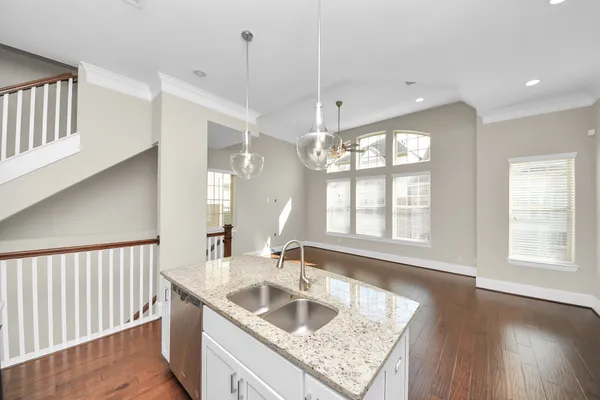 a kitchen with stainless steel appliances kitchen island granite countertop a stove a sink a dining table and chairs