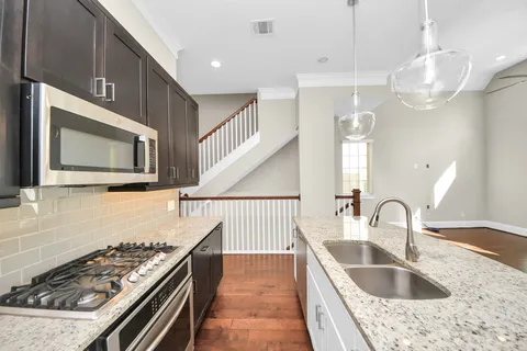 a kitchen with granite countertop a sink stove and cabinets