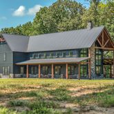 an aerial view of residential house with outdoor space and trees all around