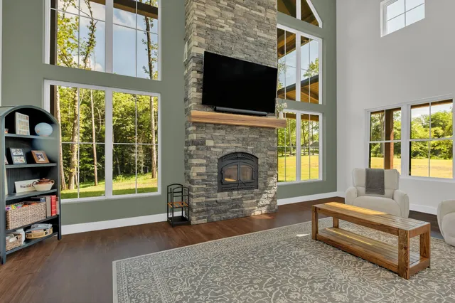 a large kitchen with kitchen island a large island in the center a sink stainless steel appliances wooden floor and a large window