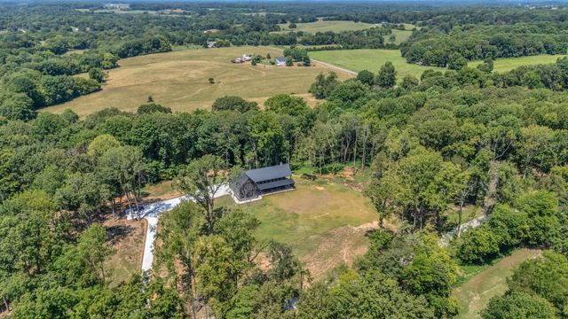an aerial view of a house with a yard and lake view