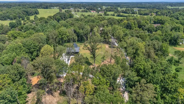 an aerial view of a house with swimming pool and porch