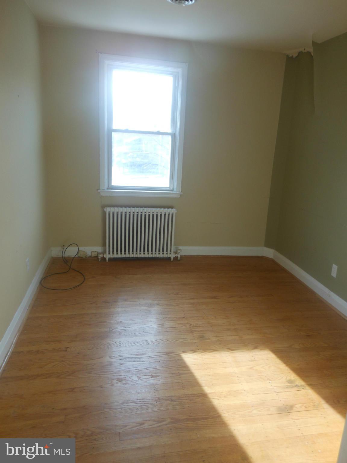 516 Charing Cross Road Baltimore, MD 21229 - Photo 9 of 9 a view of an empty room with wooden floor and a window