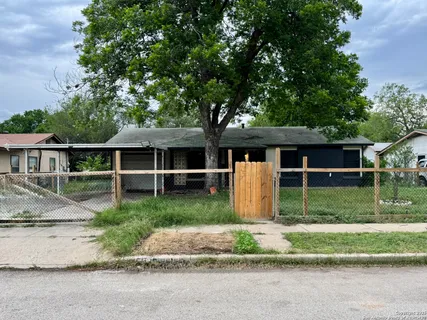 a front view of a house with a yard and large tree