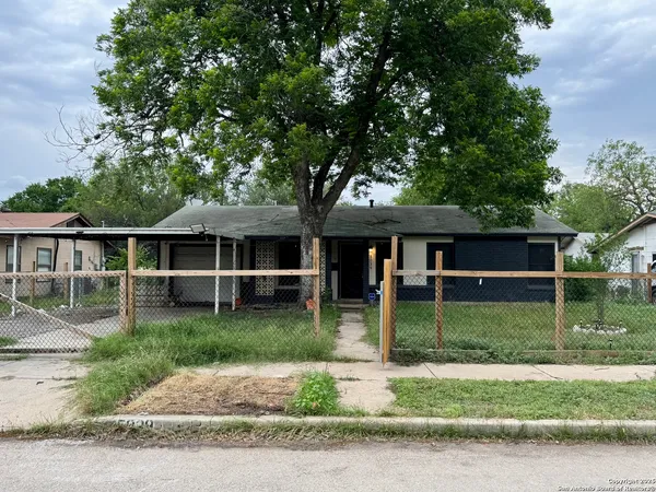 a view of a yard in front of a house with large tree