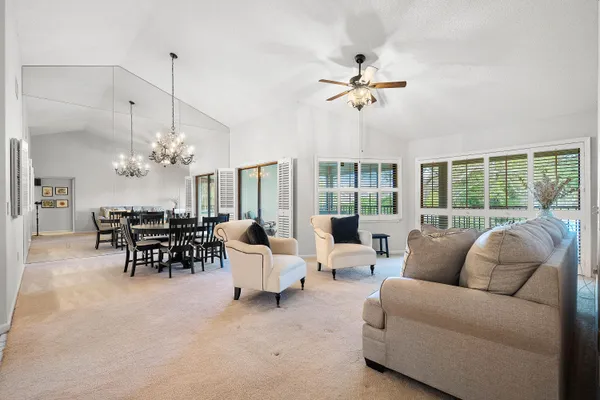 a living room with furniture ceiling fan and a large window