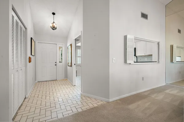 a view of a hallway with wooden floor and a bathroom