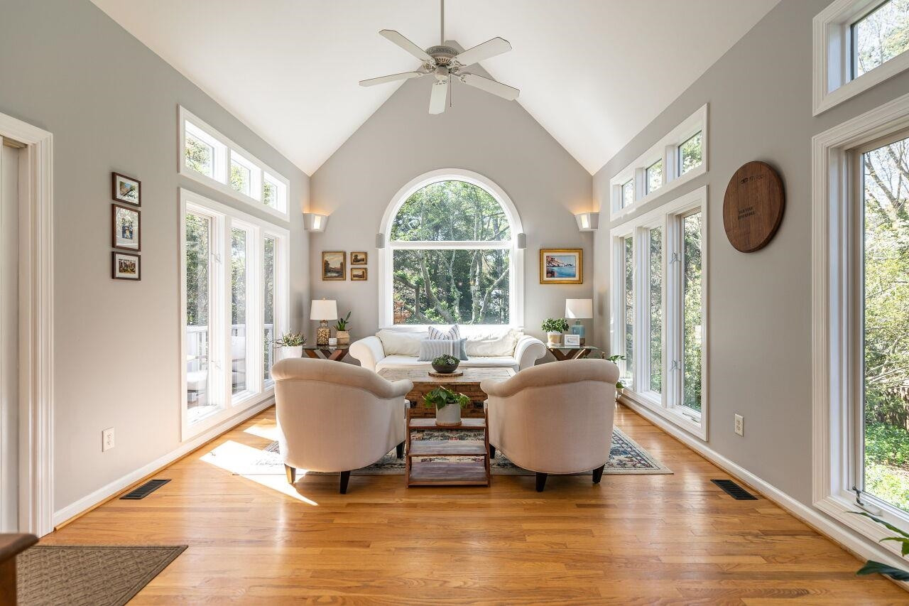 5905 Stable Court Raleigh, NC 27612 - Photo 13 of 30 a living room with couches a mirror and a large window with garden view