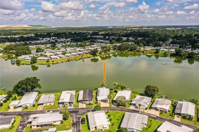 a kitchen with stainless steel appliances granite countertop a refrigerator a stove and a sink with wooden cabinets