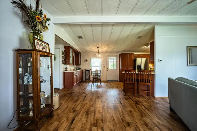 a kitchen with stainless steel appliances granite countertop a refrigerator a stove and a sink with wooden cabinets