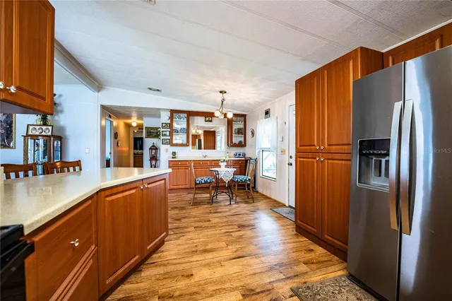 a dining room with stainless steel appliances kitchen island granite countertop a refrigerator and a stove top oven