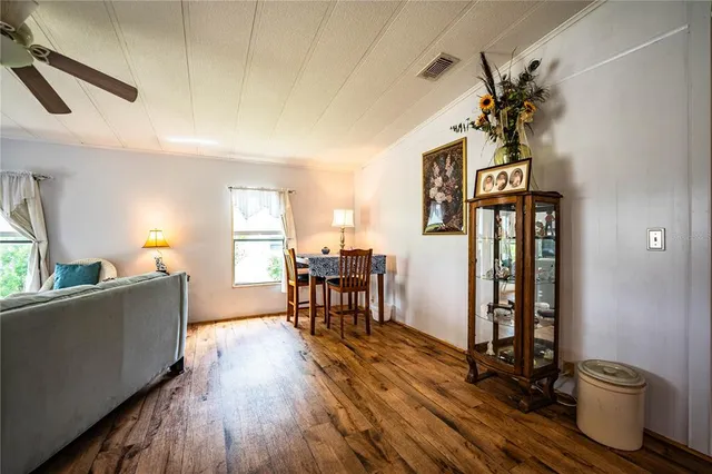 a kitchen with stainless steel appliances granite countertop wooden cabinets a refrigerator a sink a stove a dining table and chairs