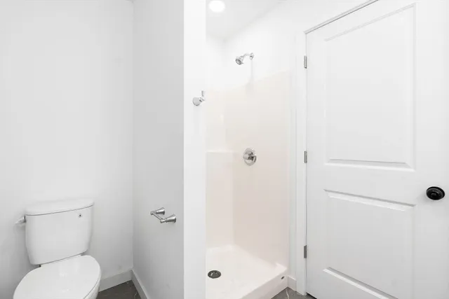 a bathroom with a toilet and a shower