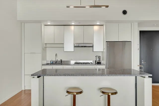 a kitchen with stainless steel appliances granite countertop a refrigerator a sink and a stove