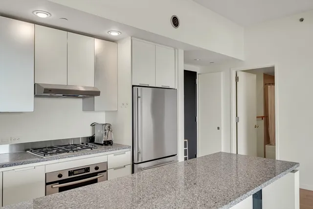 a kitchen with stainless steel appliances granite countertop a stove a refrigerator and a granite counter tops