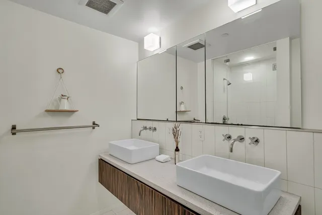 a bathroom with double vanity sink and a mirror