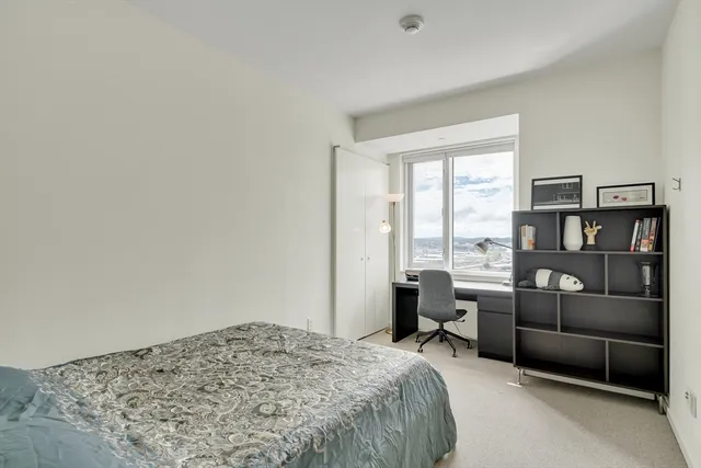 a bedroom with a bed couch and a large window