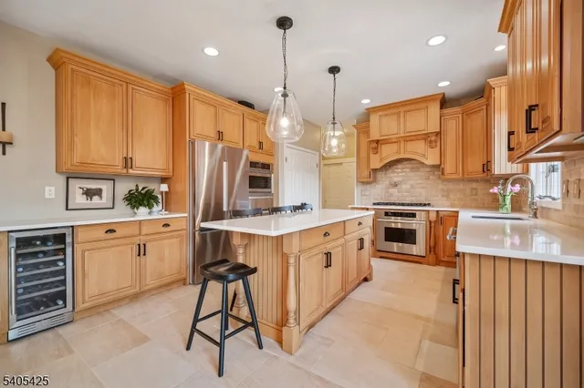 a kitchen with stainless steel appliances kitchen island granite countertop a table chairs in it and wooden floors