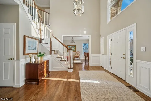 a living room with furniture a chandelier and a dining table