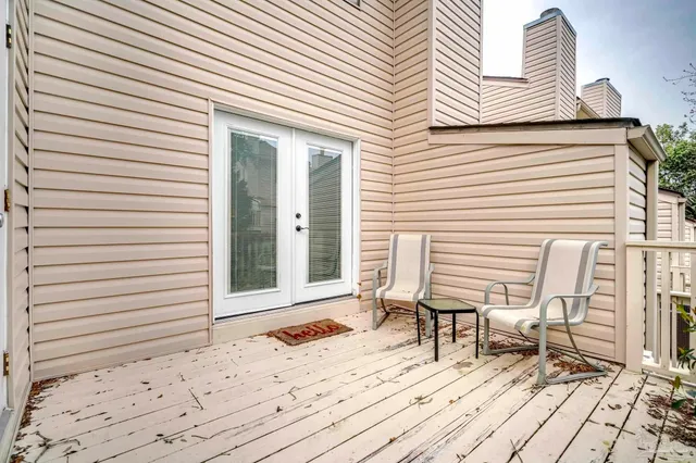 a deck with chair and table in front of it