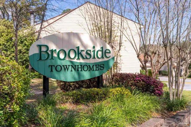 a sign board with street sign and a yard