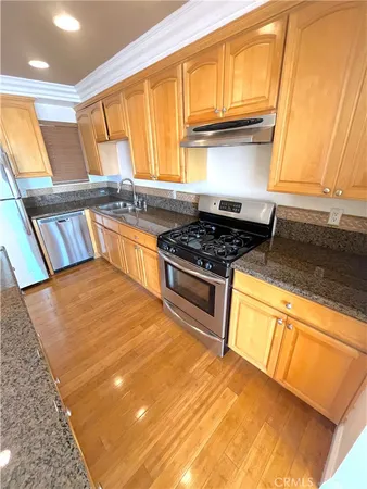 a kitchen with stainless steel appliances granite countertop a stove a sink and a microwave