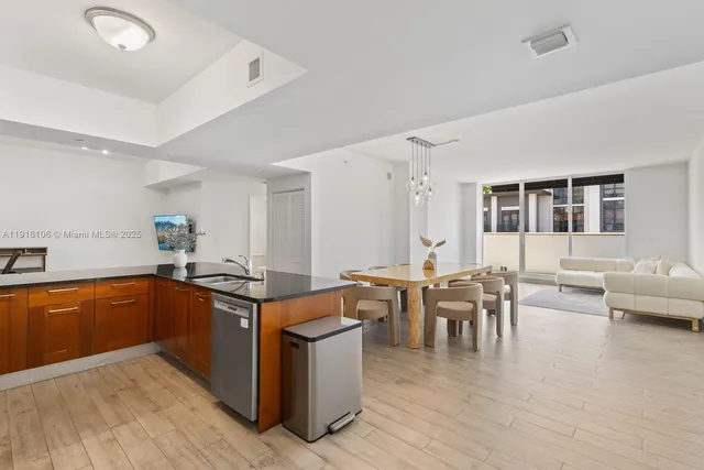a kitchen with stainless steel appliances granite countertop a sink refrigerator and cabinets