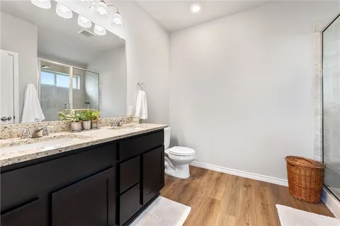 a bathroom with a granite countertop sink mirror and toilet