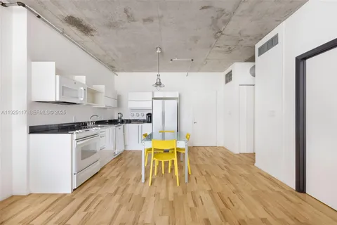 a kitchen with stainless steel appliances granite countertop a white cabinets and wooden floor
