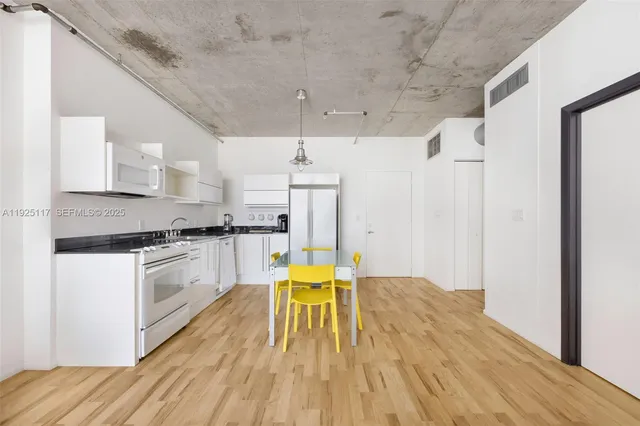 a kitchen with stainless steel appliances granite countertop a white cabinets and wooden floor
