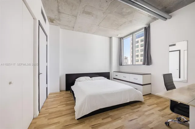 a bedroom with a bed and wooden floor