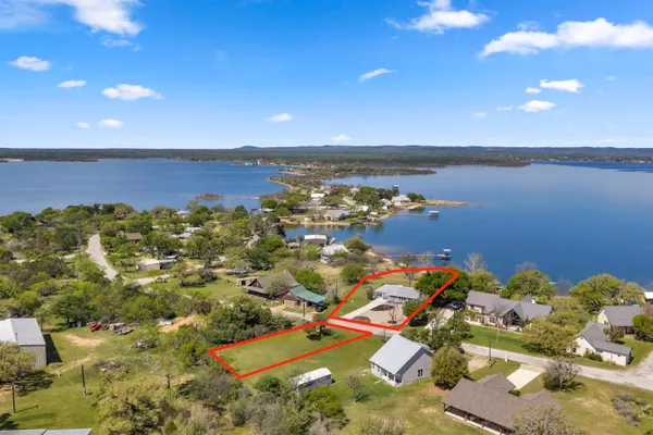 an aerial view of ocean and residential houses with outdoor space