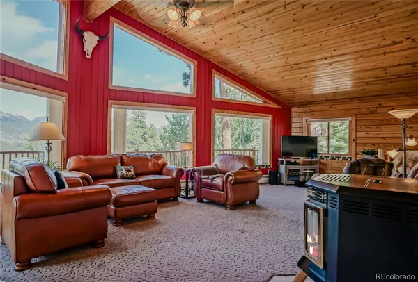 a living room with furniture a fireplace and a large window